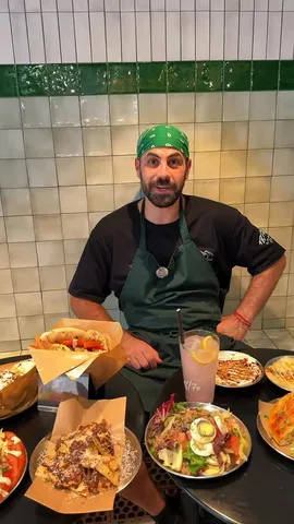 En DosManos, con pitas y platos sobre la mesa ante la pared de azulejos